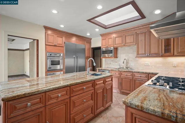a kitchen with stainless steel appliances granite countertop a refrigerator and a stove
