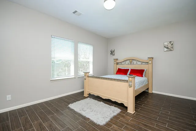 a bedroom with a bed and wooden floor