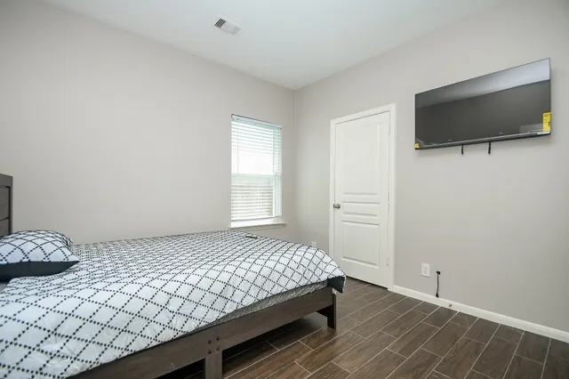 a bedroom with a bed and a flat screen tv