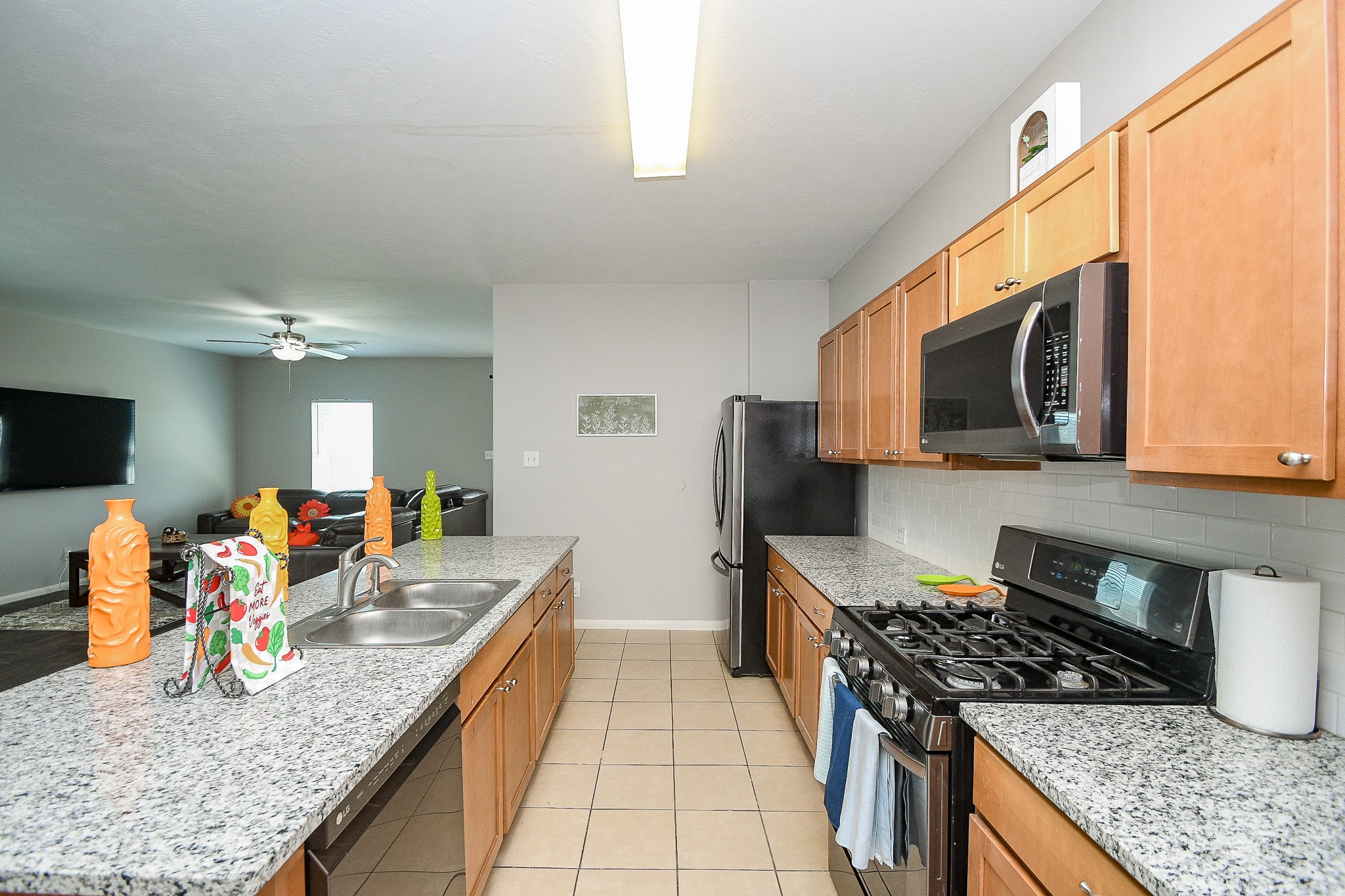 3318 Grand Cane Lane Rosenberg, TX 77471 - Photo 6 of 20 a kitchen with stainless steel appliances granite countertop a stove top oven a sink a refrigerator white cabinets and wooden floor