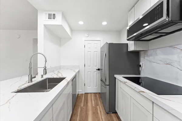 a kitchen with stainless steel appliances granite countertop a sink stove and refrigerator