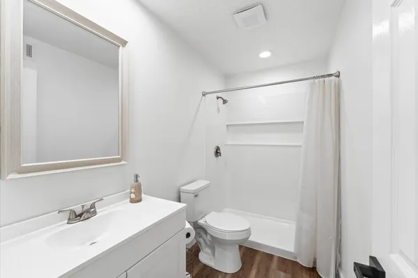 a bathroom with a toilet a sink and a mirror