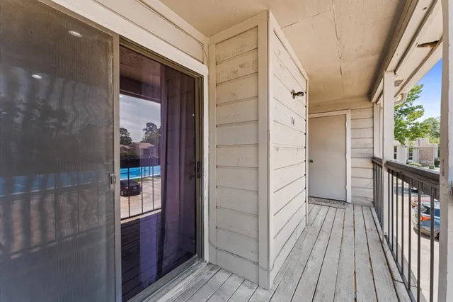 a view of balcony with floor to ceiling windows with wooden floor