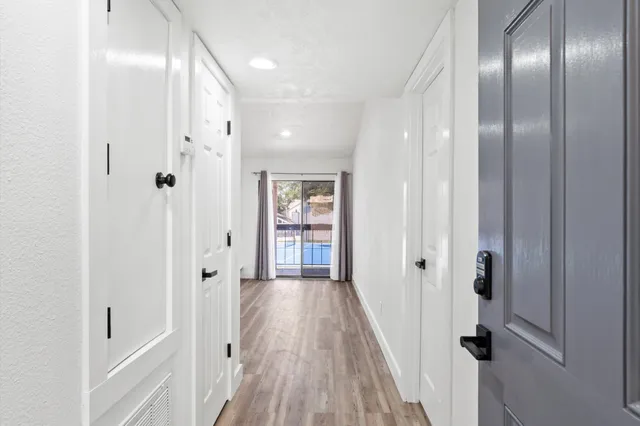 a view of a hallway with wooden floor