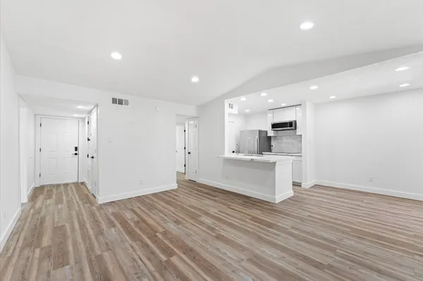 a view of kitchen with wooden floor and electronic appliances