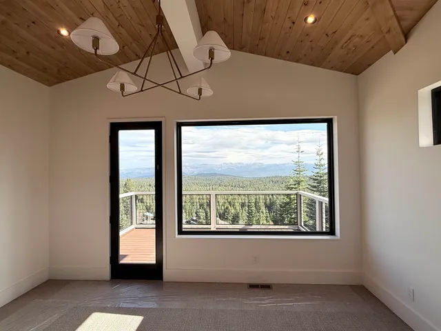 a view of a room with a large window and chandelier