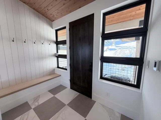 a view of an empty room with a window and a kitchen