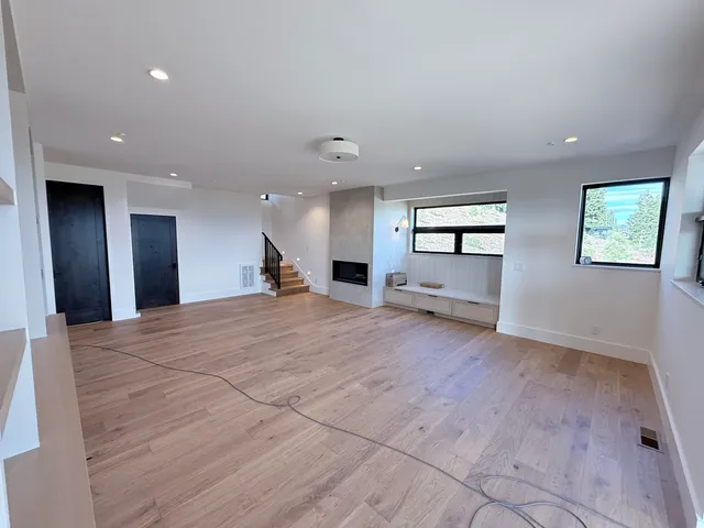 an empty room with windows and ceiling fan