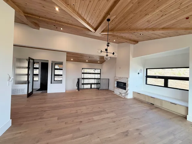 a view of an empty room with a fireplace and a window