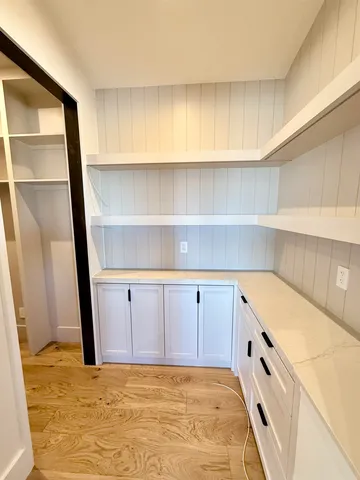 a kitchen with white cabinets and a refrigerator