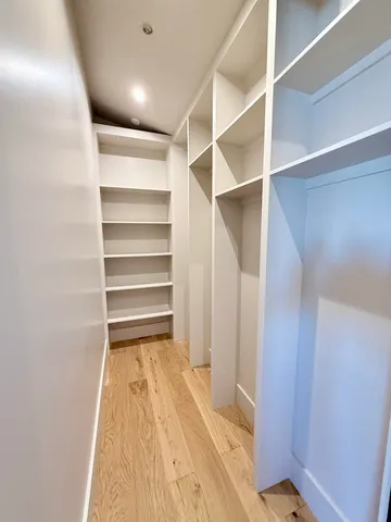 a view of walk in closet with empty racks