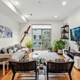 a dining room with furniture potted plants and wooden floor