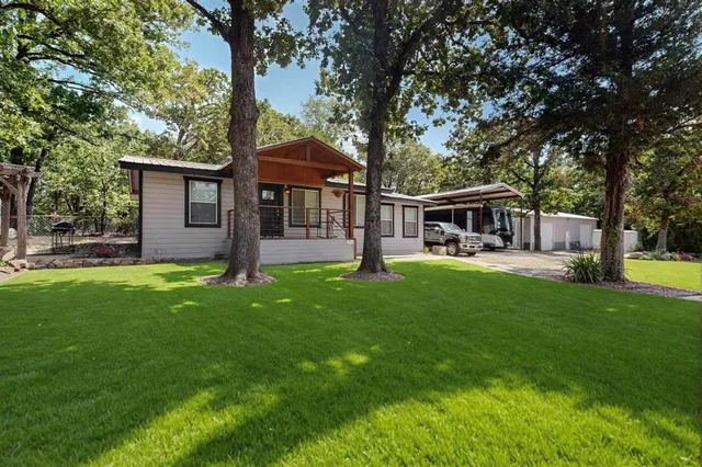 a front view of a house with yard and green space
