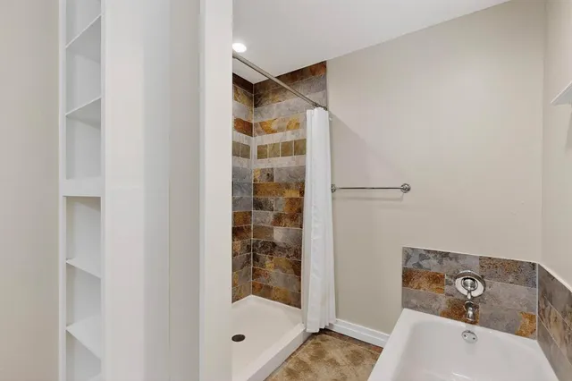 a bathroom with a bathtub and shower