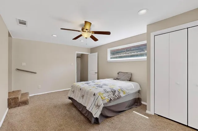 a bedroom with a bed and a ceiling fan