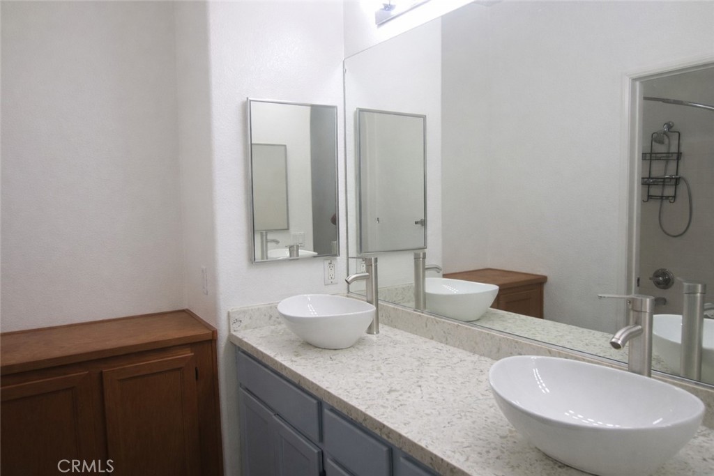 1285 Fools Gold Way, Unit 2 Chula Vista, CA 91913 - Photo 36 of 43 a bathroom with a granite countertop sink and a mirror with toilet