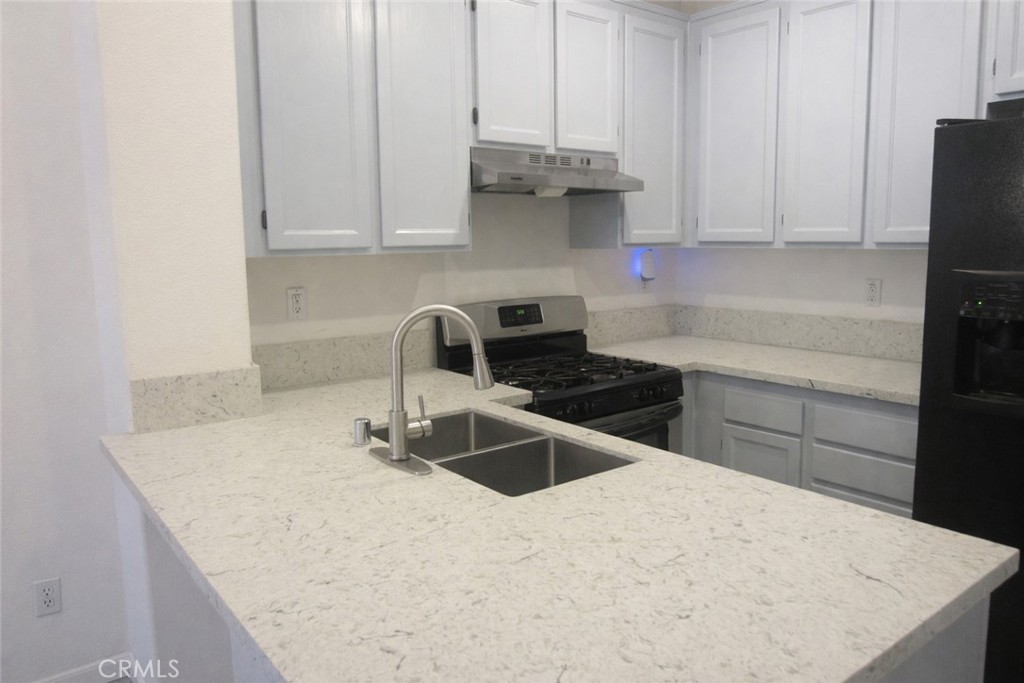 1285 Fools Gold Way, Unit 2 Chula Vista, CA 91913 - Photo 9 of 43 a kitchen with stainless steel appliances a stove a sink and white cabinets