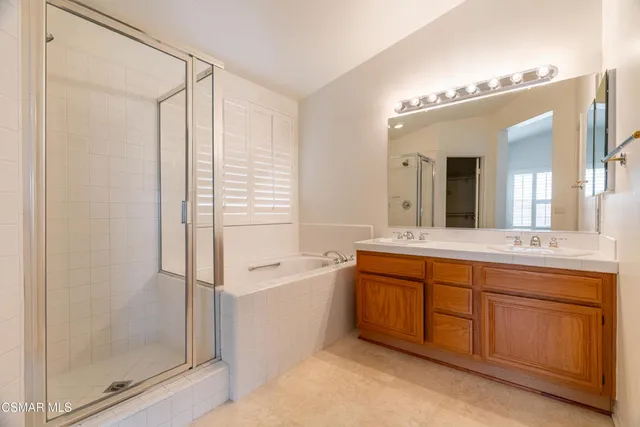 a spacious bathroom with a granite countertop sink mirror and a bathtub
