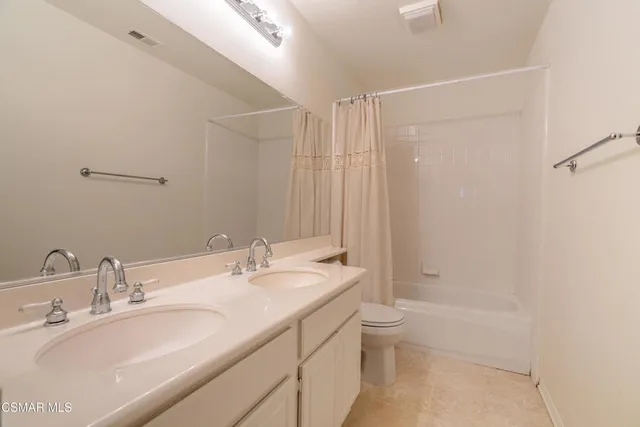 a bathroom with a granite countertop sink a toilet and shower