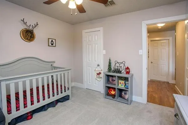 a view of a bedroom with baby crib and furniture
