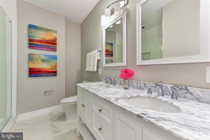 1453 Girard Street Northwest, Unit 3 Washington, DC 20009 - Photo 14 of 21 a bathroom with a granite countertop sink mirror vanity and toilet