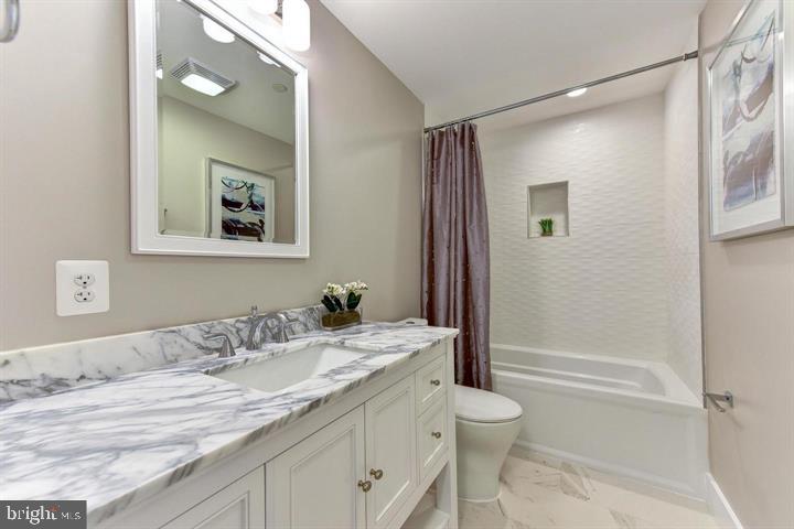 1453 Girard Street Northwest, Unit 3 Washington, DC 20009 - Photo 17 of 21 a bathroom with a granite countertop sink a toilet and shower