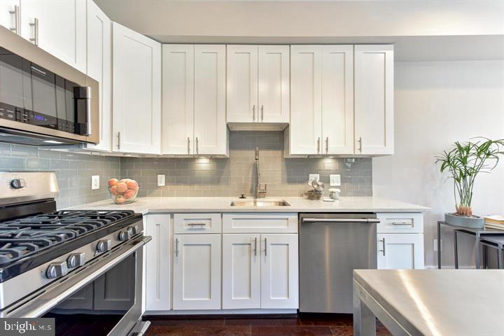 1453 Girard Street Northwest, Unit 3 Washington, DC 20009 - Photo 5 of 21 a kitchen with stainless steel appliances granite countertop a sink stove and cabinets