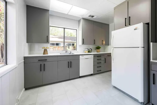 a kitchen with a white refrigerator a sink dishwasher a stove and a refrigerator with wooden floor