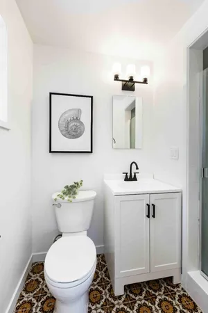 a bathroom with a toilet a sink and mirror