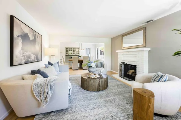 a living room with furniture fireplace and a large window