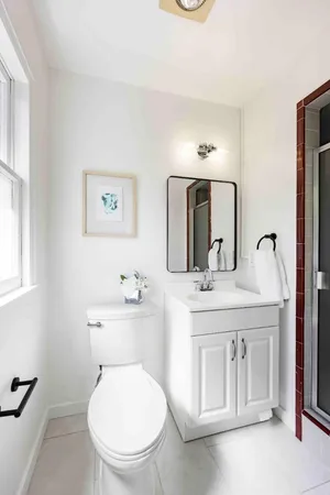 a bathroom with a toilet a sink and mirror