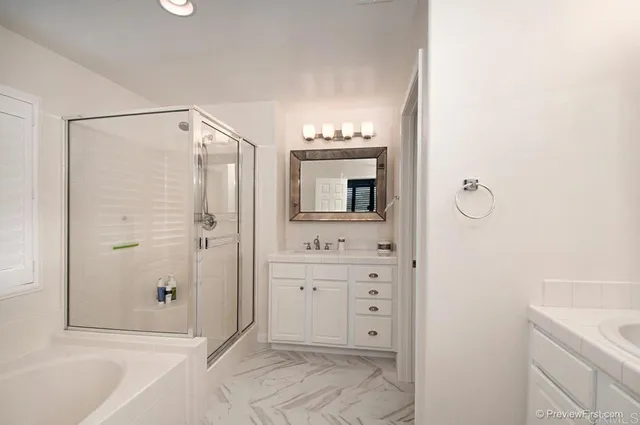 a spacious bathroom with a shower sink and mirror