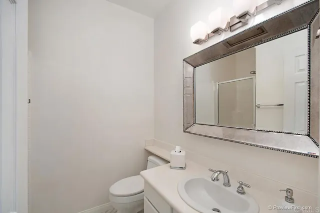 a bathroom with a toilet a sink and mirror