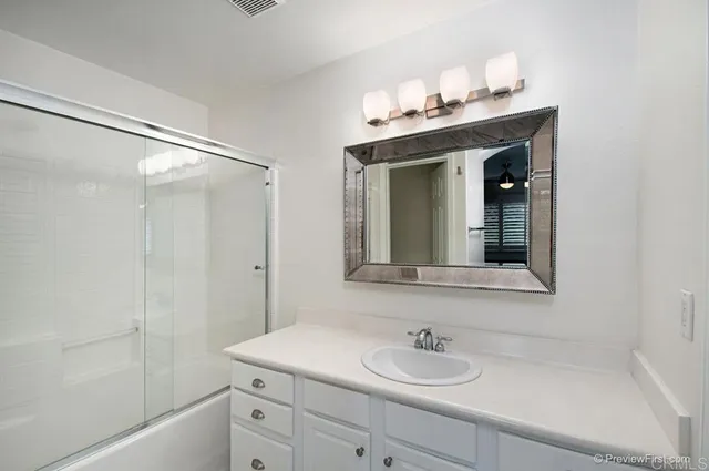 a bathroom with a sink vanity granite tub and shower