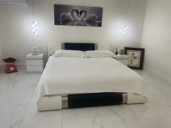 a bedroom with a bed and painting on the wall