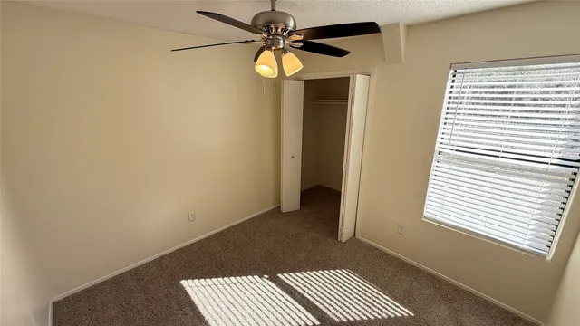 a view of a room with a window and a ceiling fan