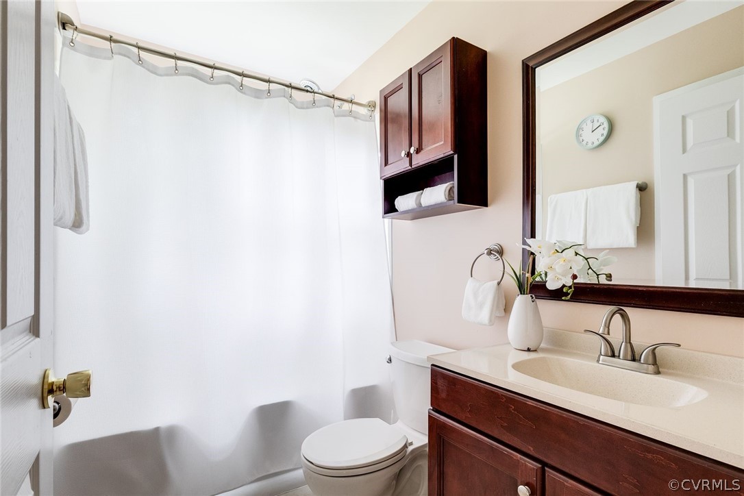 7547 Cherokee Road Richmond, VA 23225 - Photo 21 of 29 a bathroom with a granite countertop sink toilet a mirror a vanity and shower