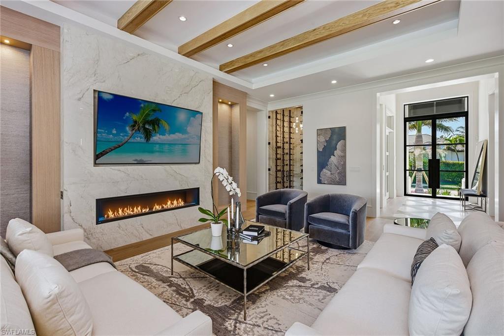 529 Neapolitan Way Naples, FL 34103 - Photo 4 of 26 a living room with furniture and a flat screen tv