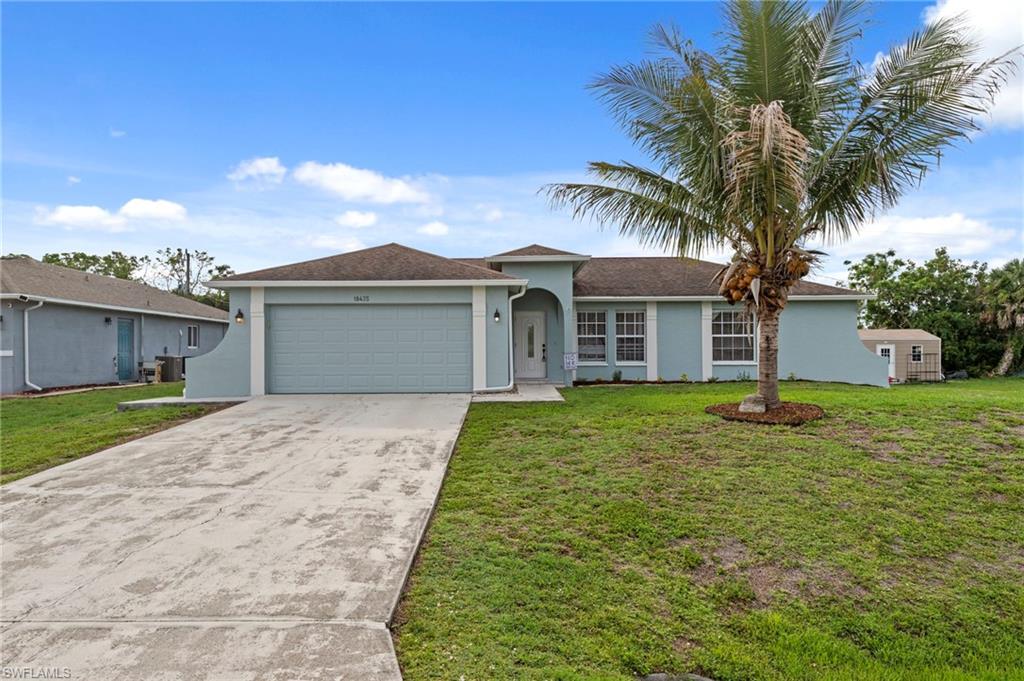 18435 Heather Road Fort Myers, FL 33967 - Photo 1 of 34 Light blue stucco exterior featuring a two-car garage, mature palm tree, and concrete driveway