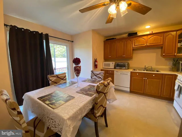 a living room with stainless steel appliances kitchen island granite countertop furniture and a refrigerator