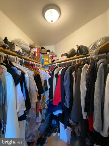 a view of walk in closet with clothes and shoes