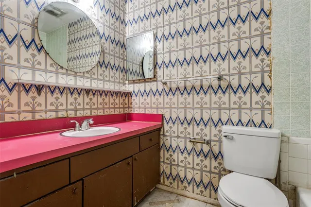 a bathroom with a sink a toilet and a shower curtain