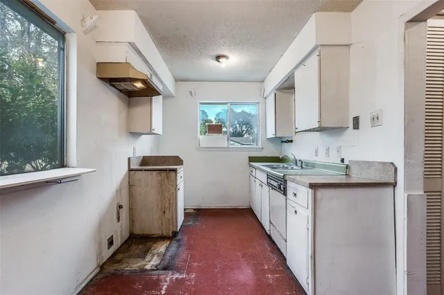 a kitchen with granite countertop a sink stove and cabinets