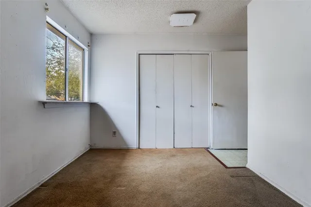 an empty room with windows and closet
