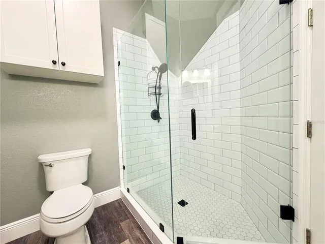 a bathroom with a toilet and a shower