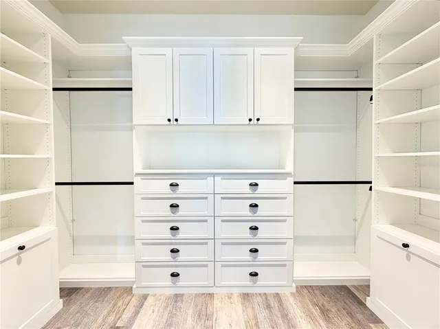 a view of walk in closet with empty racks