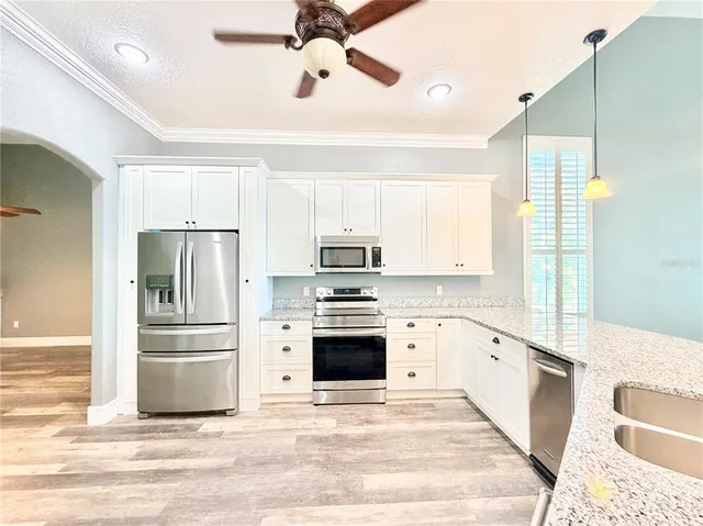 a kitchen with stainless steel appliances a stove a refrigerator and a sink