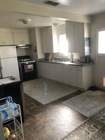 a kitchen with stainless steel appliances kitchen island granite countertop a sink stove and refrigerator