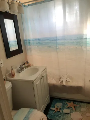 a bathroom with a sink toilet and mirror