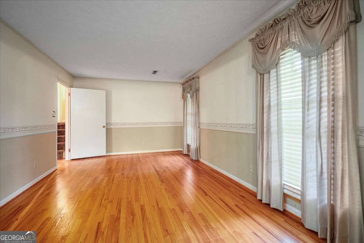 11302 Jefferson Road Athens, GA 30607 - Photo 10 of 75 a view of an empty room with wooden floor and a window